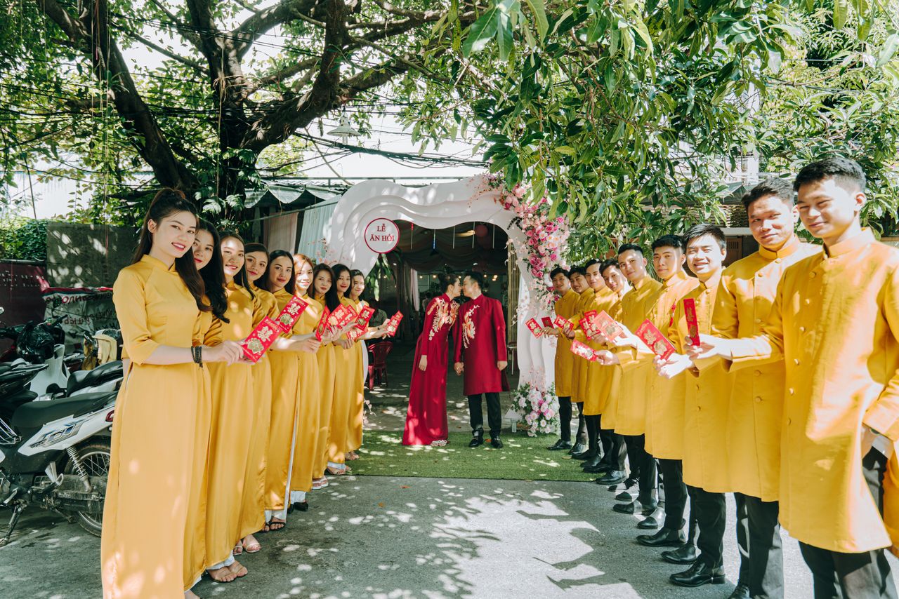 Wedding procession with couples in traditional clothing. Joyful and colorful celebration outdoors.